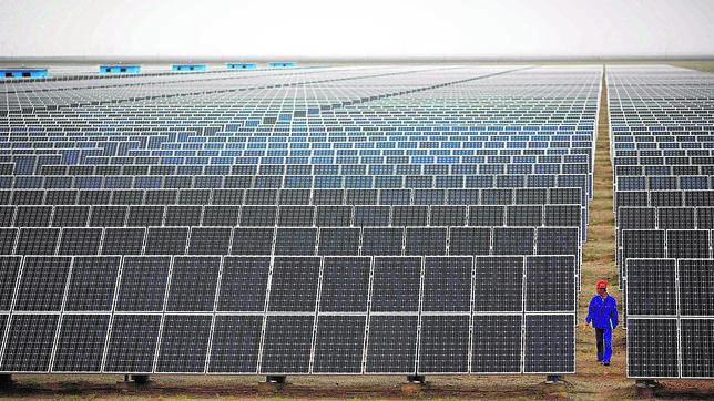 A worker inspects solar panels at a solar farm in Dunhuang, 950km northwest of Lanzhou, Gansu Province -0VME3352.jpg-